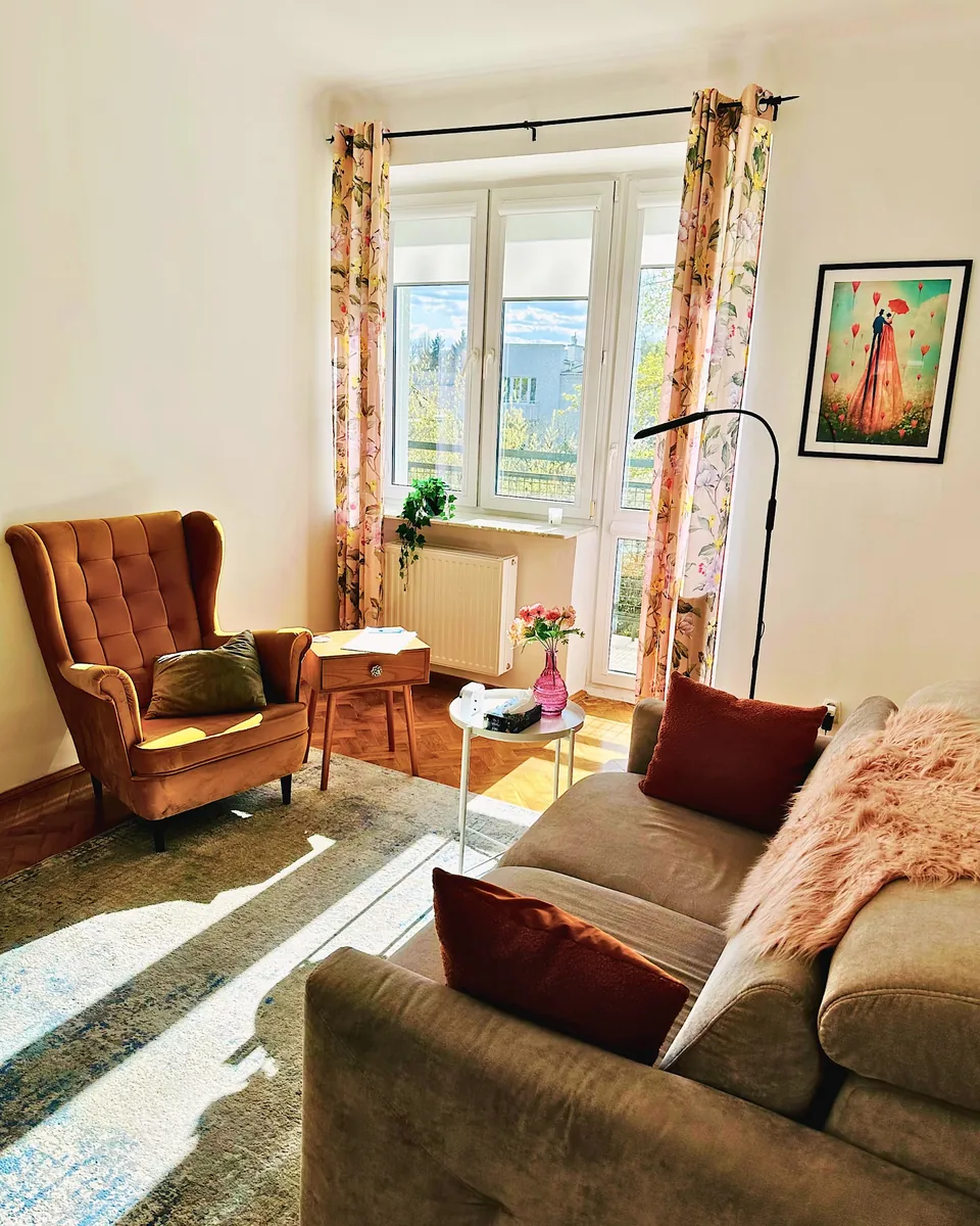 Gabinet z fotelem i sofą, w słońcu.